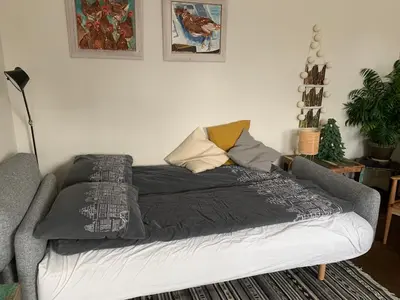 a bed in a living room with at B&B Amsterdam Amstel Apartment in Amsterdam