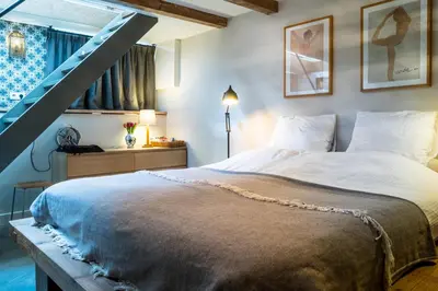 a bedroom with a large bed and a staircase at B&B Amsterdam Amstel Apartment in Amsterdam