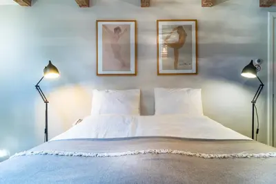 a bedroom with a bed with two lamps and two pictures on the wall at B&B Amsterdam Amstel Apartment in Amsterdam