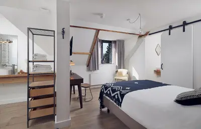 a bedroom with a bed and a desk next to a bed sidx sidx at Boutique Hotel Bellevue in Blaricum