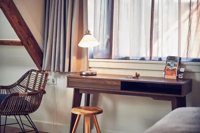 a desk in a room with a window and a chair at Boutique Hotel Bellevue in Blaricum