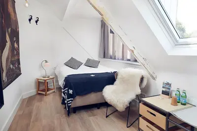 a bedroom with a bed with a chair and a window at Boutique Hotel Bellevue in Blaricum