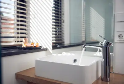 a bathroom with a white sink and a window at Boutique Hotel Bellevue in Blaricum