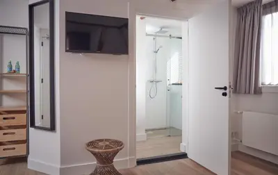 a bathroom with a walk in shower and a glass door at Boutique Hotel Bellevue in Blaricum