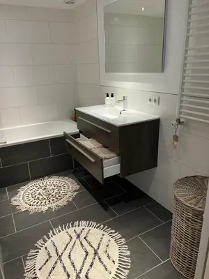 a bathroom with a sink and a tub and a mirror at Appartement van der Zee in Zandvoort