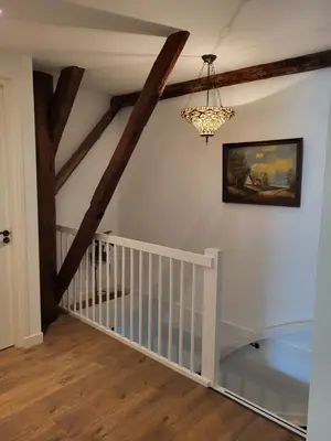 a room with a white staircase with a chandelier at B & B De Tocht in Berkhout