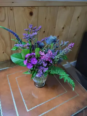 a vase filled with purple flowers on a table at B & B De Tocht in Berkhout