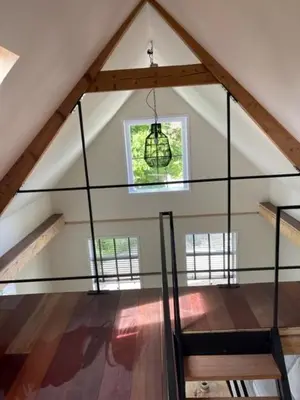 an attic room with a chandelier and a window at trendy boutique appartement vlak bij Amsterdam in Rijnsaterwoude