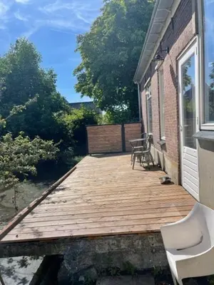 a wooden deck with a bench on a house at trendy boutique appartement vlak bij Amsterdam in Rijnsaterwoude