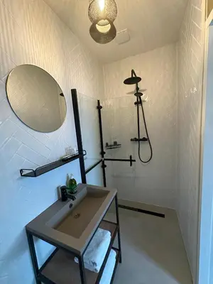 a bathroom with a sink and a mirror and a shower at trendy boutique appartement vlak bij Amsterdam in Rijnsaterwoude