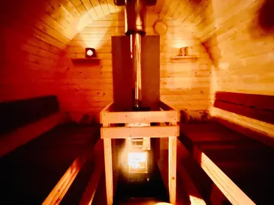 a small room with a stove in a wooden cabin at Stuga Kodawari in Voorhout