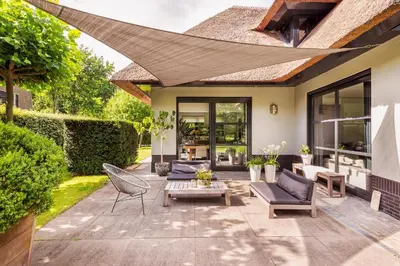 a patio with couches and a table and chairs at Villa Summer in Bergen