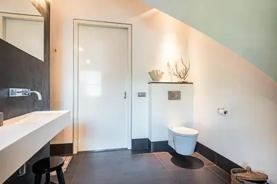 a bathroom with a toilet and a sink at Villa Summer in Bergen