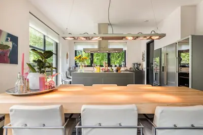 a kitchen with a large wooden table and white chairs at Villa Summer in Bergen