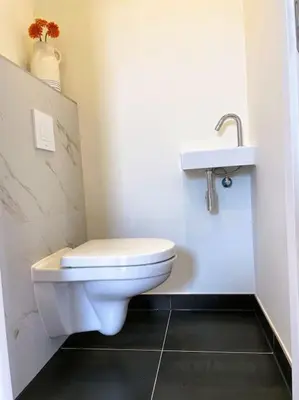 a bathroom with a white toilet and a sink at Het Zonnetje in Wijk aan Zee