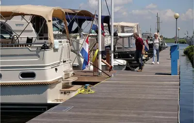 a group of people walking on a dock next to boats at 2 Bedroom Stunning Ship In Aalsmeer in Aalsmeer