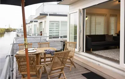 a porch with a table and chairs on a boat at 2 Bedroom Cozy Ship In Aalsmeer in Aalsmeer