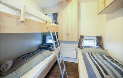 two bunk beds in a small room with a ladder at 2 Bedroom Cozy Ship In Aalsmeer in Aalsmeer