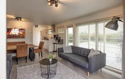 a living room with a couch and a dining room at 2 Bedroom Cozy Ship In Aalsmeer in Aalsmeer