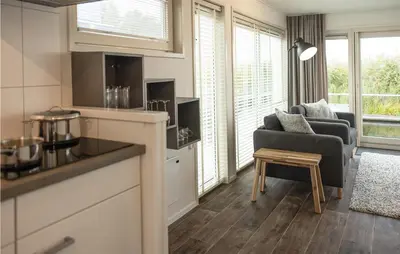 a kitchen and living room with a couch and a table at 2 Bedroom Cozy Ship In Aalsmeer in Aalsmeer