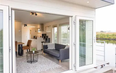 a living room and kitchen with sliding glass doors at 2 Bedroom Cozy Ship In Aalsmeer in Aalsmeer