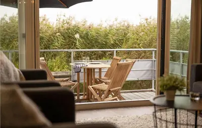a patio with a table and chairs on a balcony at Awesome Ship In Aalsmeer With Lake View in Aalsmeer