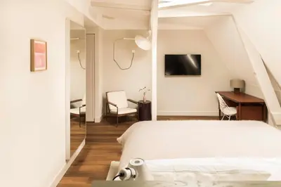 a bedroom with a bed and a desk and a tv at Boutique Hotel Weesp in Weesp
