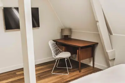 a room with a desk and a chair next to a staircase at Boutique Hotel Weesp in Weesp