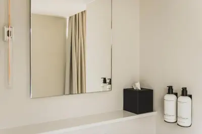 a bathroom with a mirror and two bottles on a shelf at Boutique Hotel Weesp in Weesp