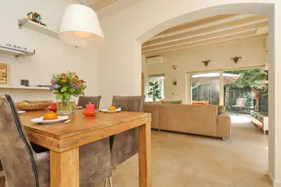 a living room with a wooden table and a couch at Sunnybeachhouse aan het bos, tussen zee en meer. in Noordwijkerhout