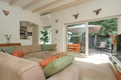 a living room with a couch and an umbrella at Sunnybeachhouse aan het bos, tussen zee en meer. in Noordwijkerhout