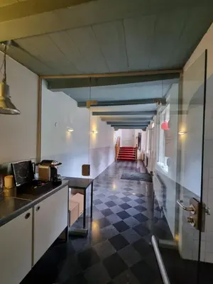 a kitchen with a checkered floor and a hallway at Het Waterhof in Leiden