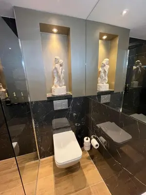 a bathroom with a toilet and two statues on the wall at Het Waterhof in Leiden