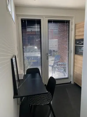 a black desk and chairs in a room with windows at Studio34 Zandvoort free parking in Zandvoort
