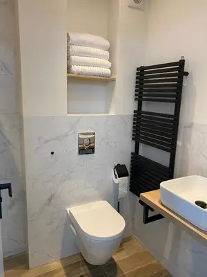 a bathroom with a toilet and a sink and towels at Studio34 Zandvoort free parking in Zandvoort