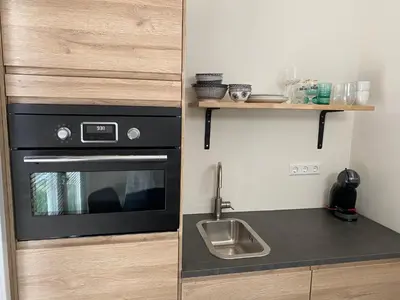 a small kitchen with a sink and a stove at Studio34 Zandvoort free parking in Zandvoort
