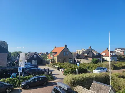a small town with cars parked in a parking lot at Pension Canberra in Bergen aan Zee
