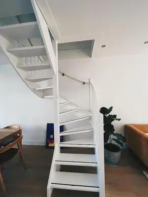 a white spiral staircase in a living room at Spacious Designer Duplex next to Central Park in Amsterdam