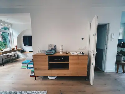 a living room with a wooden dresser in a room at Spacious Designer Duplex next to Central Park in Amsterdam