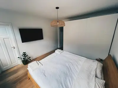 a bedroom with a white bed and a tv at Spacious Designer Duplex next to Central Park in Amsterdam