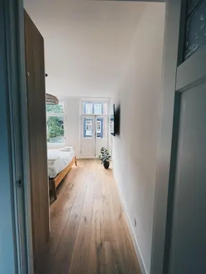 a bedroom with a bed and a hallway at Spacious Designer Duplex next to Central Park in Amsterdam