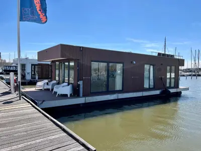 a small house on a dock on the water at 6 personen luxe houseboat Splendid Monnickendam nabij Amsterdam in Monnickendam