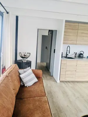 a living room with a couch and a kitchen at 6 personen luxe houseboat Splendid Monnickendam nabij Amsterdam in Monnickendam