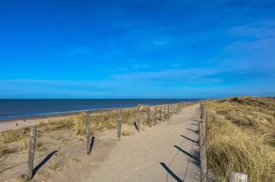a sandy path leading to the ocean on a beach at Vakantiewoning 't Juttershuis Egmond aan Zee in Egmond aan Zee