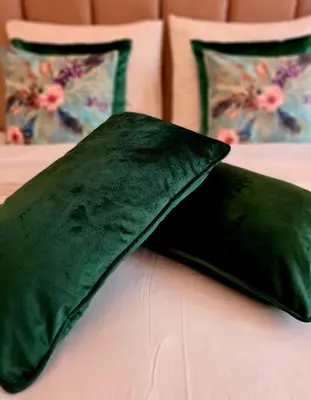 a black pillow on a bed with two pillows at Amberdi Apartment Amsterdam Schiphol Airport in Hoofddorp