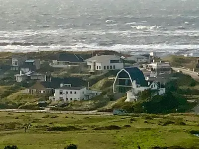 a group of houses on a hill next to the ocean at appartement Ideaal in Bergen aan Zee