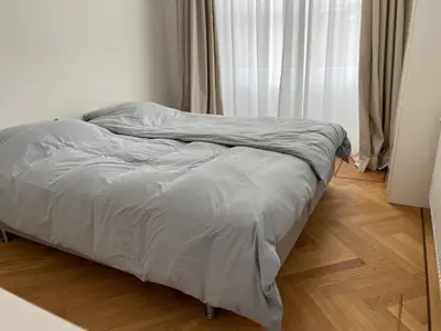 an unmade bed in a bedroom next to a window at Canal House in Historic City Center Gouda in Gouda