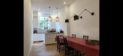a kitchen and dining room with a red table and chairs at Canal House in Historic City Center Gouda in Gouda