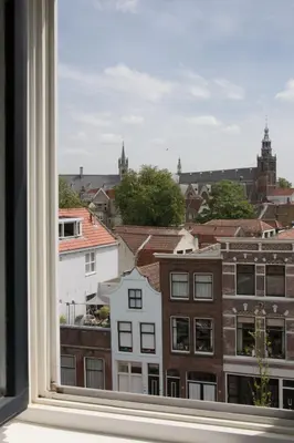 an open window with a view of buildings at Canal House in Historic City Center Gouda in Gouda