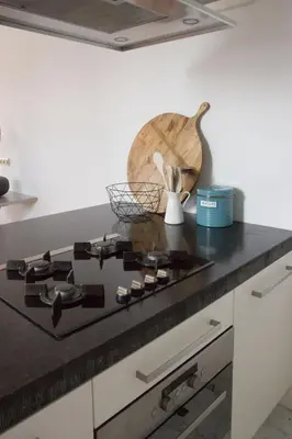 a kitchen counter with a black stove top oven at Canal House in Historic City Center Gouda in Gouda
